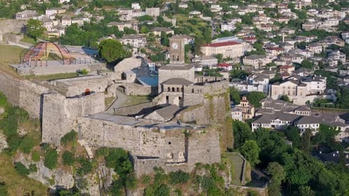 Castle of Gjirokastra high angle drone telephoto view with city in background, warm morning light