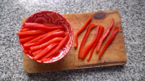 Sliced Red Bell Peppers on Board with Bowl