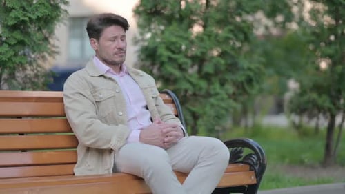 Thoughtful Man Waiting on a Park Bench