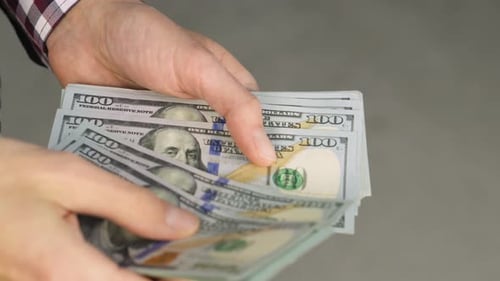 Hand Counting Stack of One Hundred Dollar Bills