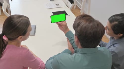 Rear View of Mixed Race People Holding Phone with Green Screen