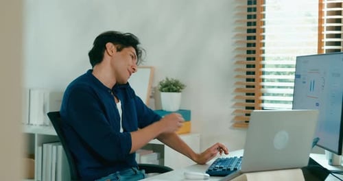 Young Adult Working at Computer in Home Office