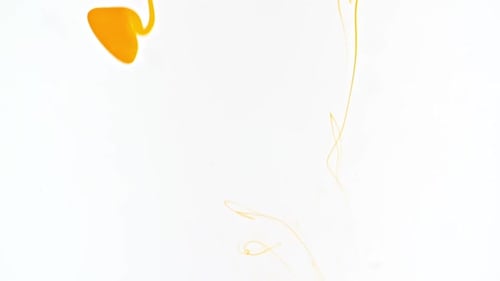 Yellow Liquid Swirls and Spreads in Clear Water