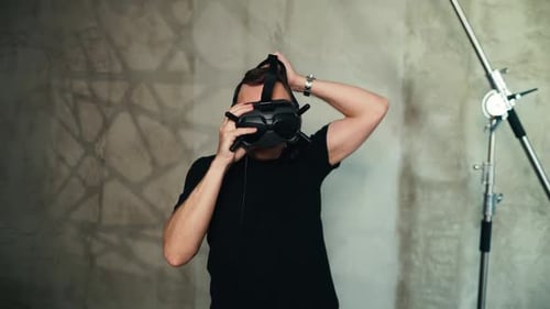 Indoors Pilot Holds and Wears Modern FPV Drone Goggles