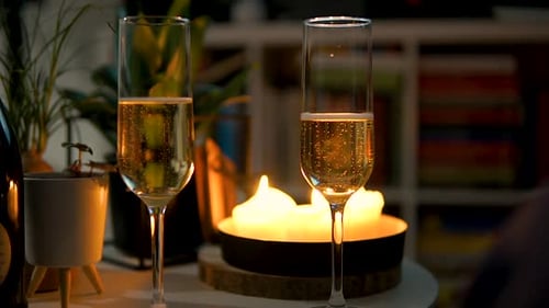 Pair Of Flute Glasses Filled With Bubbly Champagne On The Table With Candlelights. close up