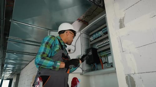 Skilled Electrician Performing Maintenance on Electrical Panel