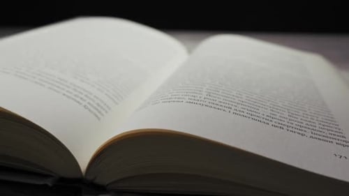 Book Pages Turning Quickly on Wooden Table
