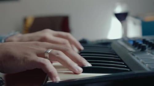 Hands Playing Keyboard Keys in Home Studio