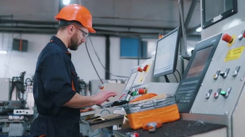 Seitenansicht, Bedienung der Maschine. Der Fabrikarbeiter ist mit Schutzhelm drinnen.