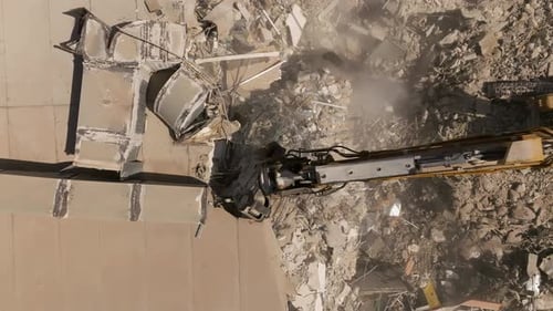 Building demolition excavator using Pulverizer Jaws to demolish a residential building