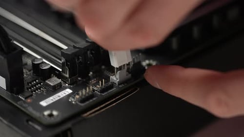 Extreme Closeup of Unrecognizable Man Plugging Power Cable Connector From Motherboard to SSD Drive