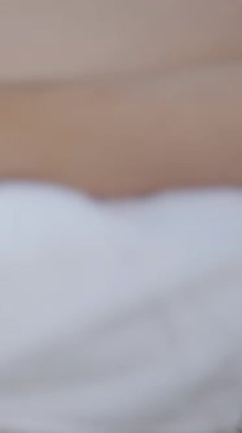 Feet and Hands of Unrecognizable Masseuse Performing Relaxing Massage at the Beach Detail Shot