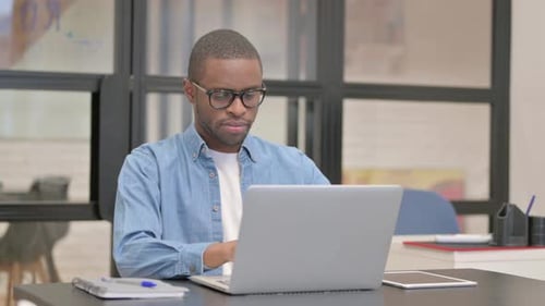 African Businessman Working on Laptop in Office
