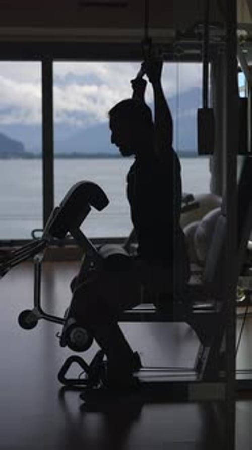 The Silhouette of a Dedicated Person Engaged in Working Out in a Beautiful Scenic Gym Environment