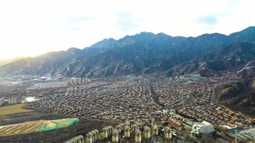 Establishing aerial shot of Jackson Hole, near Beijing, China. Sunset with mountain range.