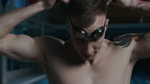 Tattooed Man Putting on Swimming Goggles