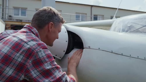 Private Airplane Engine Inspection by Aviation Engineer Close Up. Focused White Plane