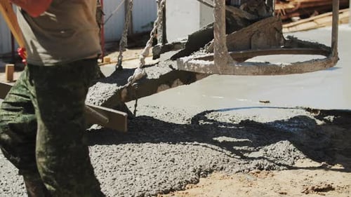A Builder Pours a Concrete Foundation