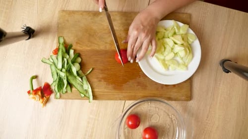 09Gurke wird mit einem Messer in Stücke geschnitten. Gerichte aus Gemüse kochen.