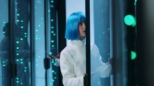Una mujer de cabello azul navega por la tecnología en una sala de servidores