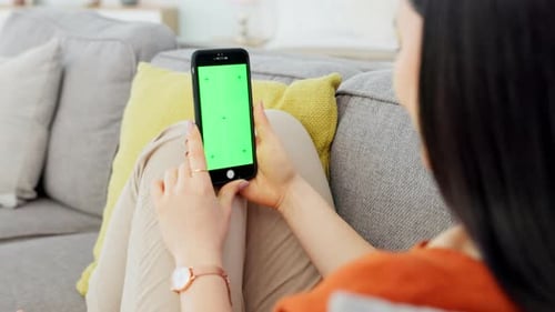 Green screen smartphone, mockup and sofa woman relax in living room with mobile app advertising