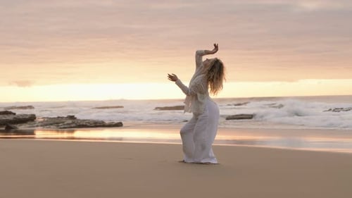 Elegant Woman Dancing Alone on a Serene Beach at Sunset