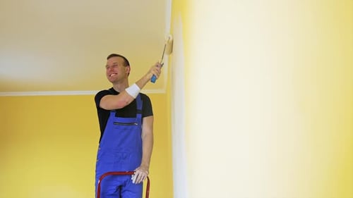 Attractive handsome repairman doing renovation the wall.
