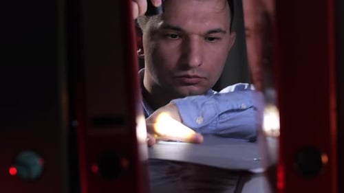 Detective Shines a Flashlight on Folders with Documents on a Shelf