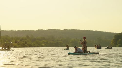 Group Of Travelers Practicing Paddle Boarding In River In Summertime SUP Touring Sport