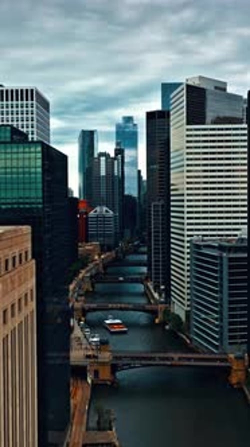 Aerial view of Chicago's modern skyline along the river under cloudy skies