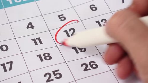 A printed monthly calendar with several dates circled in red