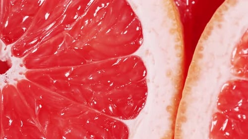 Slow Motion of Rotation Ripe Sliced Grapefruites Circles of Fresh Citrus As Food Background Tropical
