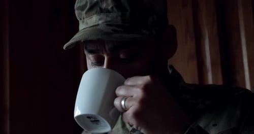 Soldat de l'armée attentionné buvant du café seul