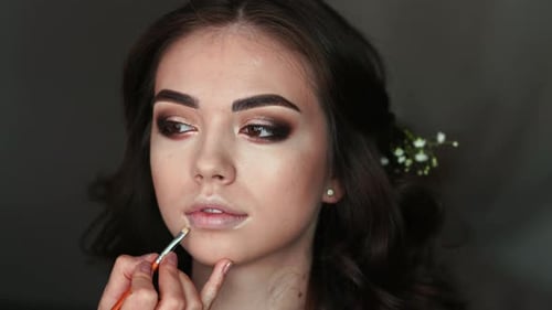 Makeup Artist Paints Lips of the Bride on the Wedding Day