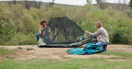 Couple Pitches Tent Together in Rural Outdoors