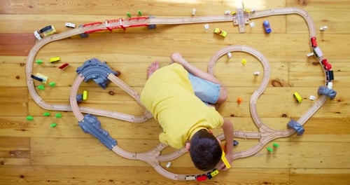Child Playing with Wooden Train Set, Birds Eye View