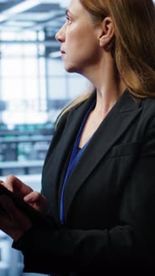 Woman Uses Tablet in Modern Server Room