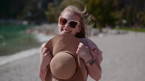 Positive Frau entspannt sich im Sommer im Urlaub am Seeufer