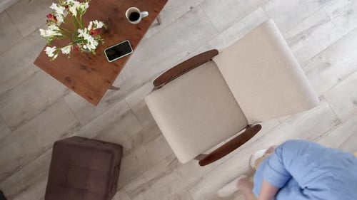 Top Down View of Chair in Which Freelancer in Blue Shirt Sits Down with Laptop and Works Man Starts