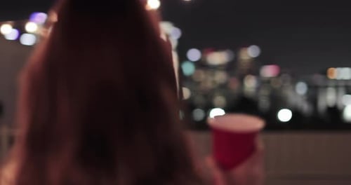Young adult couple looking at city skyline at a party