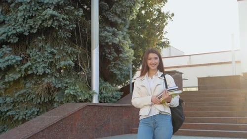 Young Girl Student Walking Down the Stairs Near University or Office Building