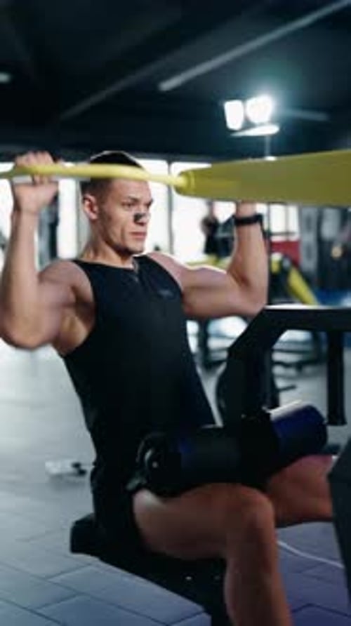 Hombre musculoso realizando flexiones planas en un gimnasio moderno