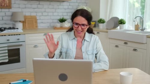 Woman with Laptop Video Calling in Bright Kitchen