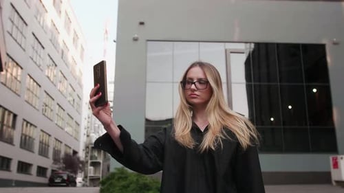 Frau in der Sonne macht im Sommer Selfie auf dem Smartphone in der Großstadt, das Lächeln entspannt die Frau, die Natur genießt