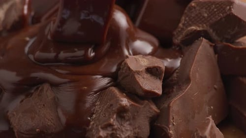 Pouring melted chocolate over chunks of chocolate