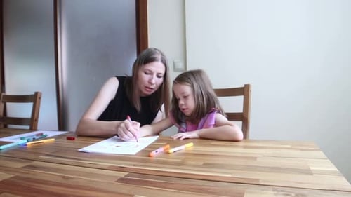 Woman and Child Drawing Together at a Table