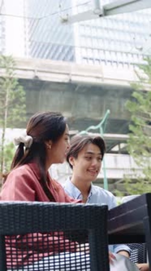 Young Couple Enjoying Conversation at Outdoor Cafe in Slow Motion