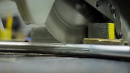 Skilled Worker Operating a Metal Saw to Cut Steel Profiles in an Industrial