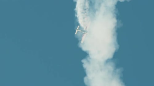 Aerobatics with Stunt Plane and White Smoke Trail