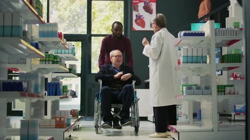 Medical Professional Reviews Prescription with Patient in Wheelchair